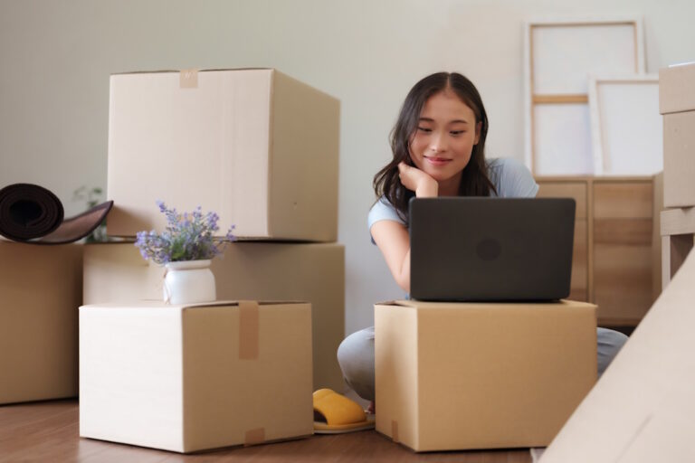 woman researching moving companies amidst boxes